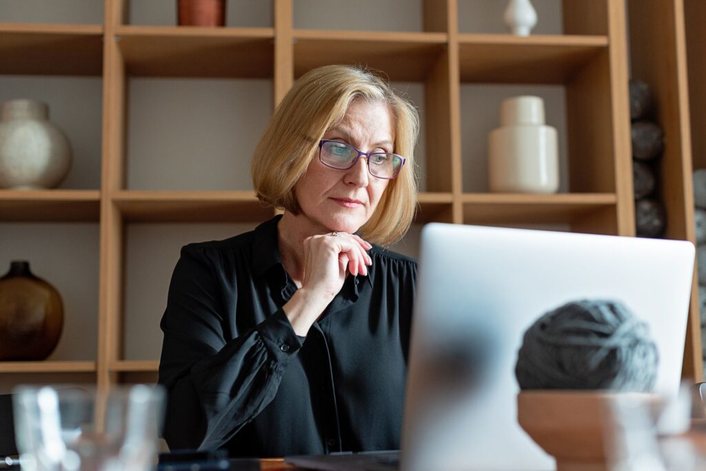 Une femme senior, sceptique, devant l'écran de son ordinateur