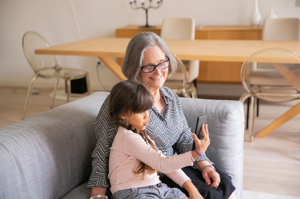 Une grand-mère et sa petite-fille regardent un téléphone ensemble